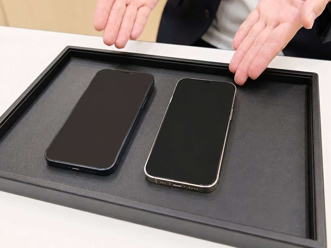 トレーに並べた2台のiPhoneを前に、データ移行の内容を説明しているところ